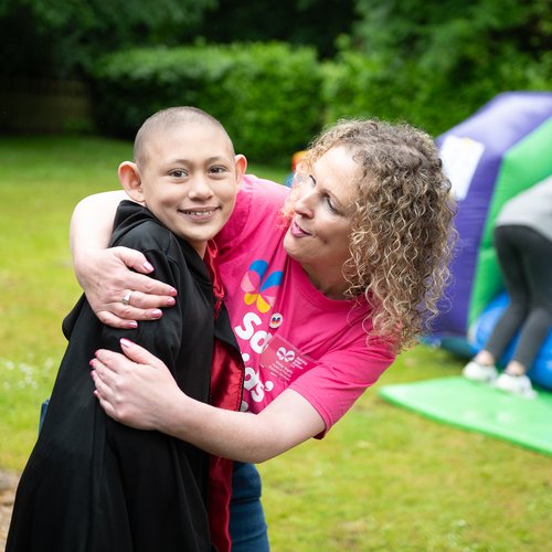 Photo of child and Solving Kids' Cancer UK staff member at a charity family fun day