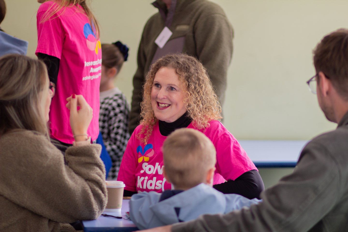 Photograph of Solving Kids' Cancer UK's Head of Family Support smiling and talking with a family.