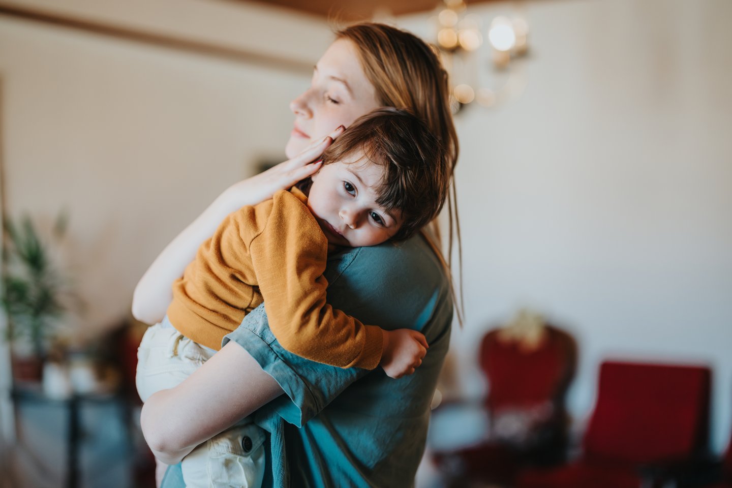 Photograph of a mother holding and embracing her toddler child
