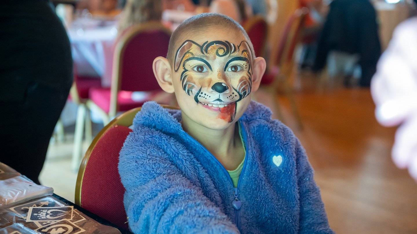 Picture of a child with neuroblastoma wearing face paint at a Solving Kids' Cancer family day