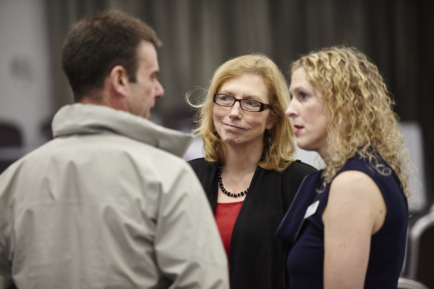 Solving Kids' Cancer UK's Head of Family Support and Family Support Advocate talking to a parent at a charity conference