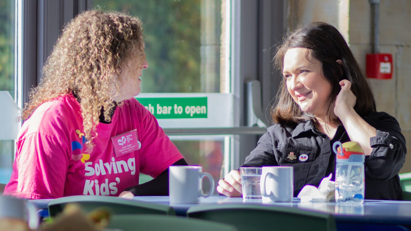 Photograph of Solving Kids' Cancer UK's Head of Family Support talking to a parent.