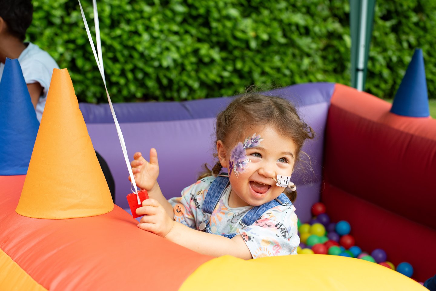 Image of a child with cancer playing in a ball pit at a Solving Kids' Cancer UK family fun day