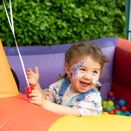 Image of a child with cancer playing in a ball pit at a Solving Kids' Cancer UK family fun day