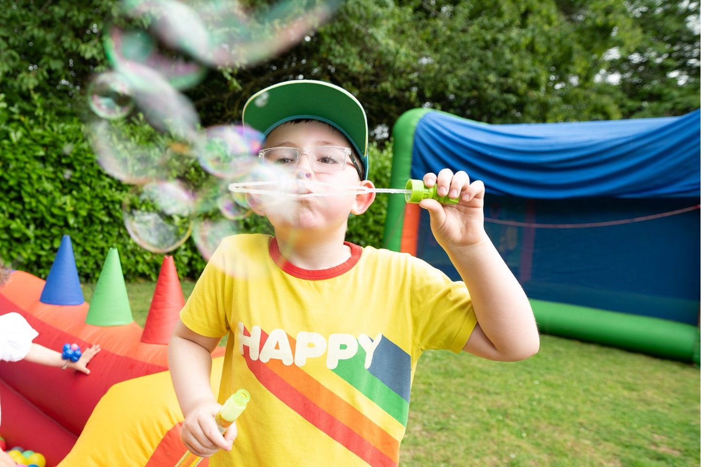 Young boy at a Solving Kid's Cancer family fun day event blowing bubbles and having fun