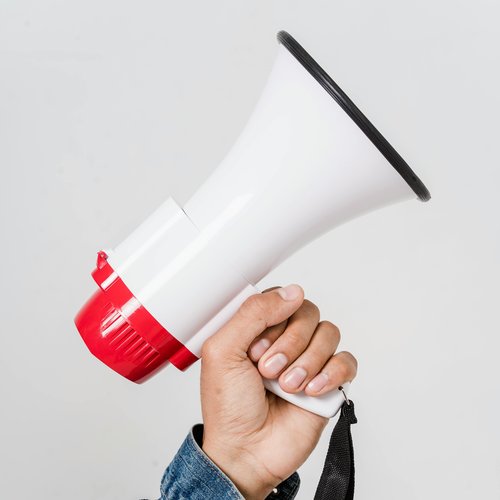 Hand holding red and white megaphone.