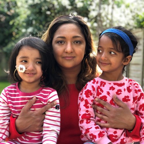Daya sat outside with her mum and twin sister